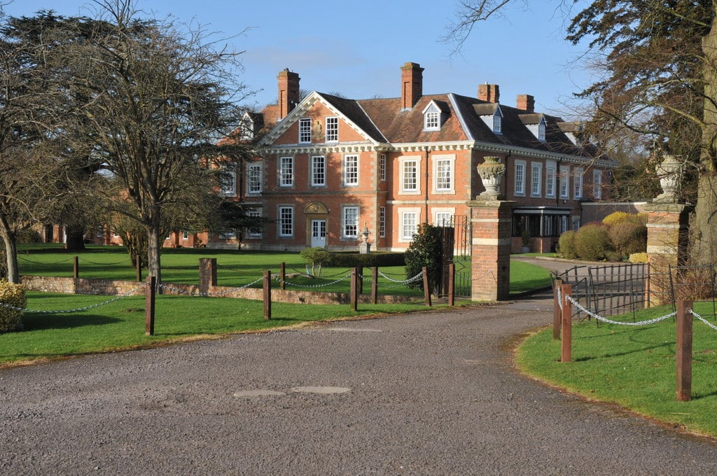 Clopton House near Stratford-upon-Avon, a red-brick house with stone dressings seen through its gate piers.