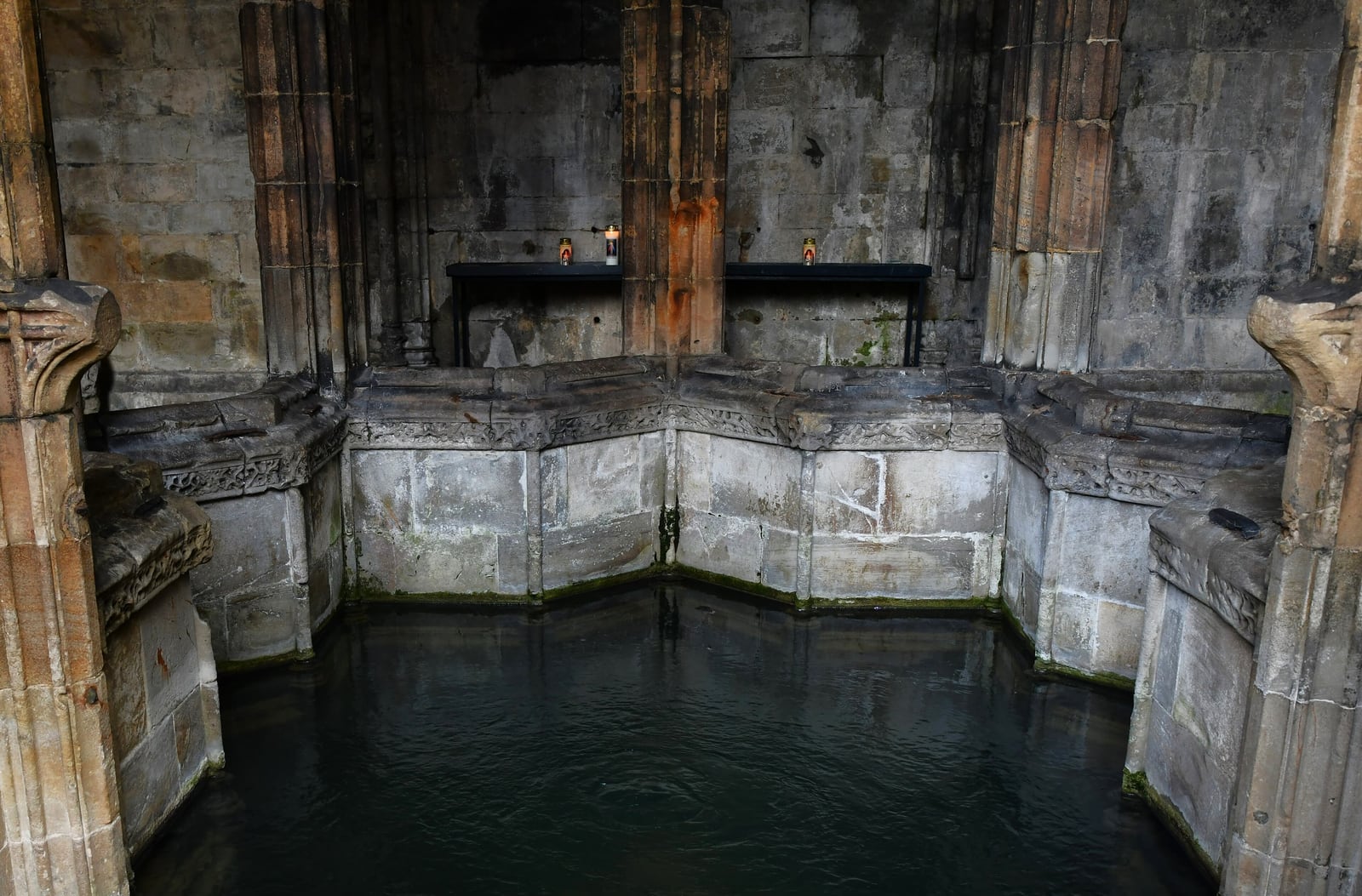 The star-shaped stone basin of St Winefride's Well at Holywell under its vaulted crypt.