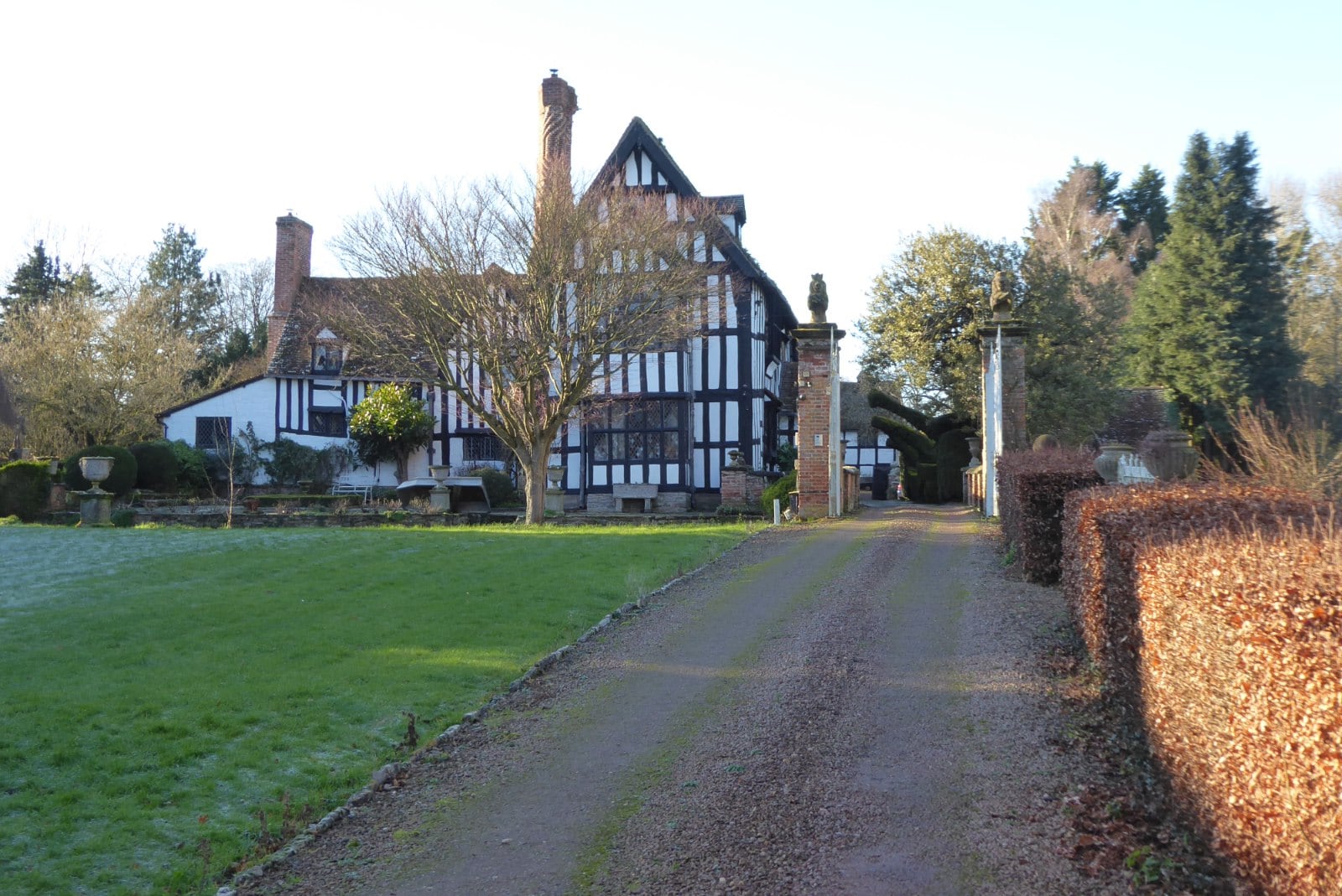 Huddington Court, Worcestershire, a close-studded timber-framed house with twisted brick chimneys, on a frosty morning.