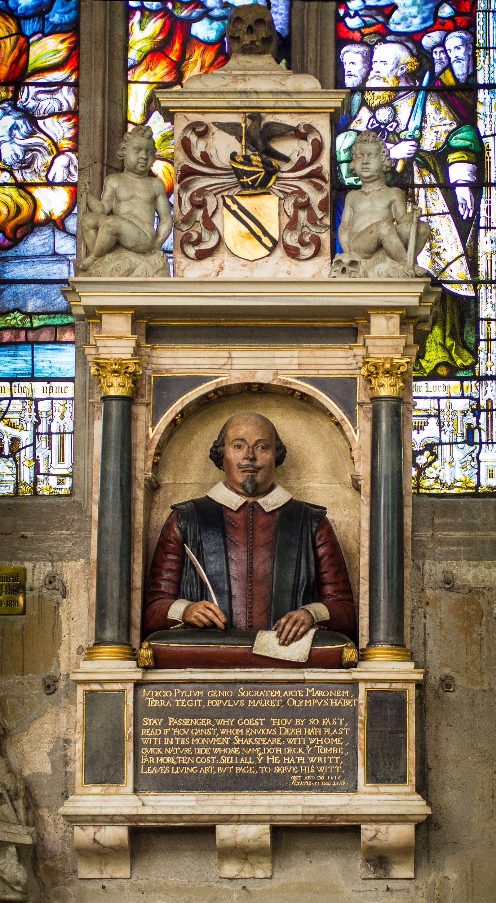 The Shakespeare funerary monument on the chancel wall of Holy Trinity Church, Stratford: the half-length bust with quill and paper under a canopy with the arms above.