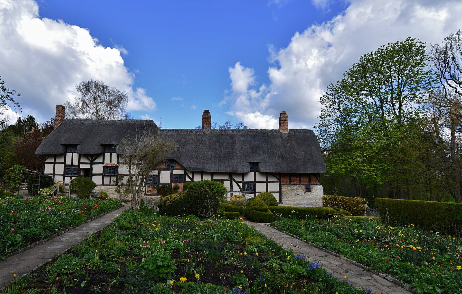 Anne Hathaway's Cottage at Shottery, a thatched timber-framed farmhouse seen from its garden.
